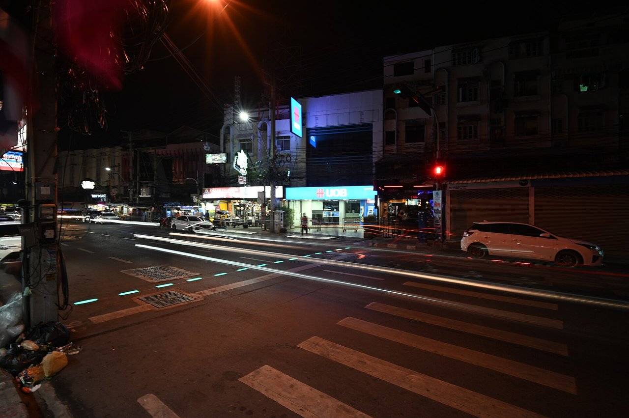 夜の交差点を走る車のヘッドライト